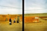femmes dans le desert rouge devant mur ocre et écriture au Maroc, en 2001 © Photo Deborah Metsch