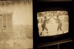 écran télévision avec le sport local qui est la boxe et écrits sur murs en sépia à Saint louis, Sénégal en 2000 © Photo Deborah Metsch